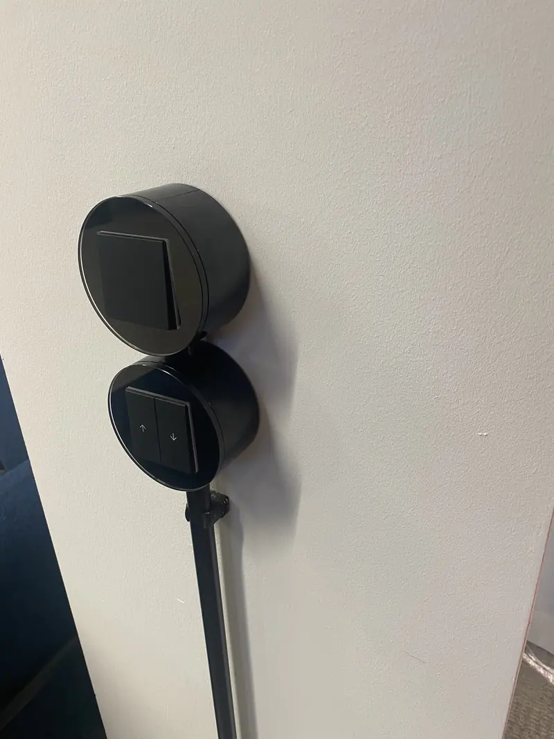 Schwarze runde Aufputz-Designschalter mit Lichtschalter und Jalousietaster, Zuleitung im schwarzen Installationsrohr