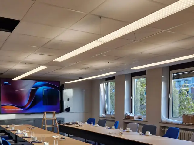 Großer Besprechungsraum mit LED-Lichtbändern in der Rasterdecke