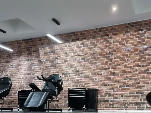 Lineare LED-Deckenleuchten in einem Studio mit Ziegelwand