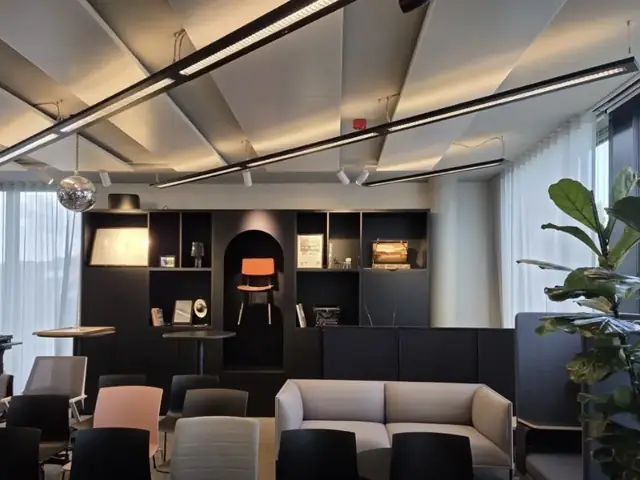 Lineare LED-Pendelleuchten über einer Lounge in einem Büro