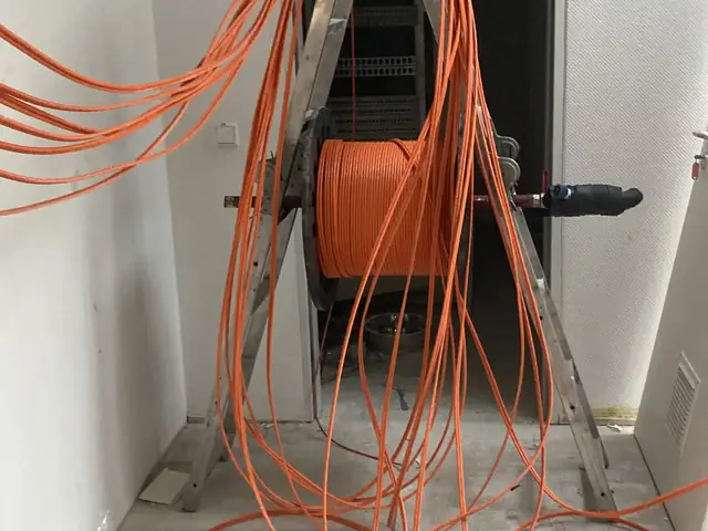 Netzwerkkabel werden von der Kabeltrommel in ein Büro eingezogen