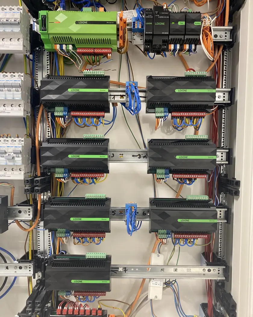 Verteiler mit Loxone Miniserver, Netzteilen, Tree- und Modbus-Extension sowie sieben Loxone-Dimmer-Extensions auf Hutschienen, sauber verdrahtet