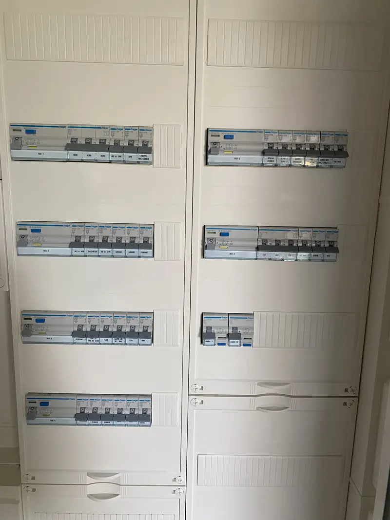 Große Unterverteilung in einem Einfamilienhaus mit sechs FI-Gruppen und beschrifteten Stromkreisen für Herd, Garage, Büro, CEE und Außensteckdosen