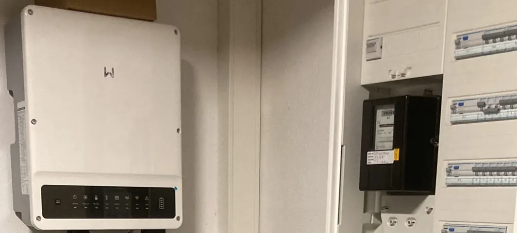 PV-Wechselrichter an der Wand neben einem Zählerschrank mit Zähler und Stromkreisverteilung – Anmeldung beim Netzbetreiber durch ElektroTechnik Posengis